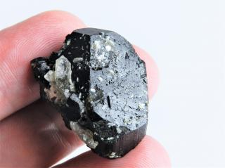 Ukončený plochý černý turmalín s krystalkem záhnědy a drobnými lupínky muskovitu