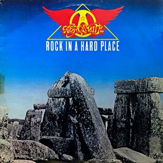 LP Aerosmith ‎– Rock In A Hard Place (Deska je mírně ohraná, mnoho jemných vlásenek. Hraje fajn, stále bezvadný a čistý zvuk. Obal je taky mírně obnošený s hrankou spravenou lep. páskou viz foto.)