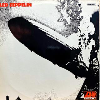 LP Led Zeppelin ‎– Led Zeppelin (Deska je v pěkném a lesklém stavu, mírně ohraná s mnoha jemnými vlásenkami. Hraje fajn, výborný zvuk, jen mírný praskot mezi skladbami. Obal je lesklý a v perfektní kondici.)