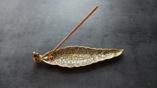 Stojánek (mosazný vzhled) ve tvaru listu s Ganéšou na vonné tyčinky
